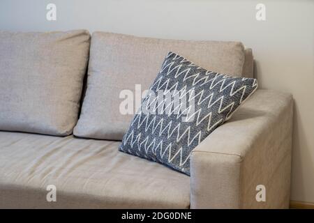 Close-up of pillows on cozy grey sofa. Soft cushion. Modern interior of living room. Stock Photo