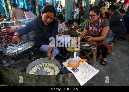 Kalimpong, India - October 2020: Two women preparing momos at the Haat Bazaar in Kalimpong on October 17, 2020 in West Bengala, India. Stock Photo