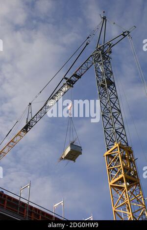 Tower Crane with cargo on It Bottom View Against soft cloudy sky Stock Photo