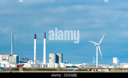 Industrial area in Copenhagen with large silos, concrete, chimneys and a wind generator.  Stock Photo