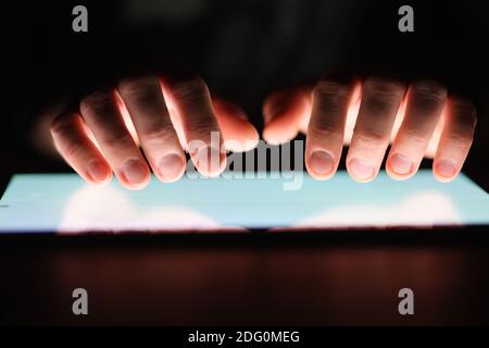 Male hands holding digital tablet at night close-up Stock Photo