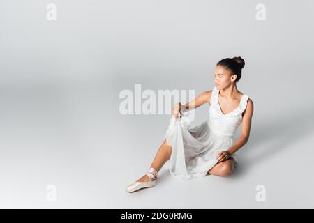 graceful african american ballerina in dress dancing on floor on white background Stock Photo