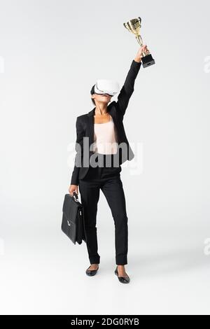 african american businesswoman with suitcase and goblet in vr headset isolated on white Stock Photo