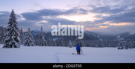 High mountains with snow white peaks. Winter forest. Amazing sunrise. A panoramic view of the covered with frost trees in the snowdrifts. Tourist stay Stock Photo