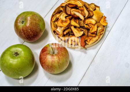 dried apples and fresh on a light wooden background Stock Photo