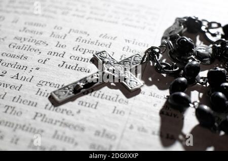 rosary beads and crucifix on old english bible Stock Photo