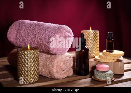 Beautiful Spa Composition. Aromatherapy with Herbal Oil, Natural Soap and Gold Candles. Relaxation Color and Warming Towels on Wooden Background Stock Photo