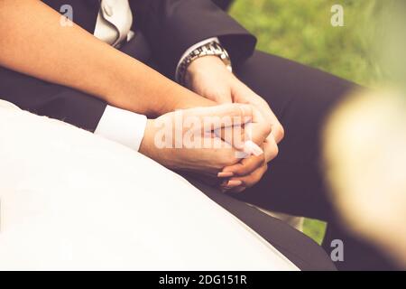 hands of two newlyweds holding hands during the ceremony Stock Photo