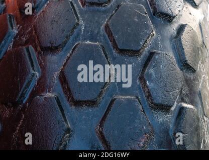 Tire treads on the rubber tire of a large construction machine. Close up.  Stock Photo