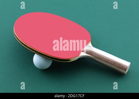 Table tennis bat and white ball on green table ping pong paddle Stock Photo