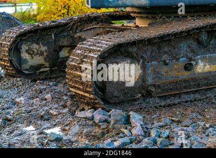 Iron tracks on a large excavator at a construction site. Close up.  Stock Photo