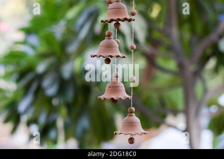 Beautiful Clay earthen pottery item Indian handicraft handmade item Terracotta windchime hanging. Clay bells hanging on with threads. Clay beads Stock Photo