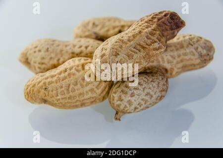 Peanuts aka groundnuts on board in shells Stock Photo