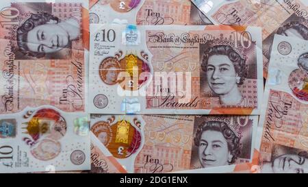 A close-up showing British ten banknotes finely detailed bronze metallic image, coloured border which changes colour from orange to purple Stock Photo