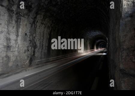 Long exposure, car light trail in a dark mountain tunnel Stock Photo