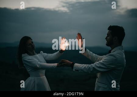 Happy Young Couple Playing with a firework at night After wedding Stock Photo