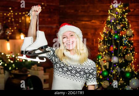 my hobby. cheerful girl red santa hat with skates. xmas holiday gift. Best present ever. happy woman love figure skating. ready for celebrate new year. winter season activity. Christmas time. Stock Photo