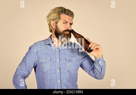 male holding bottle of beer. hipster rest in pub. Sports lover cheer up. mature man holding glass bottle of beer. drunk hipster male craft bottled beer. happy man hold full glass bottle in hand. Stock Photo