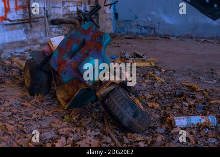 An old broken children's tricycle in an abandoned factory, broken children's tricycle Stock Photo