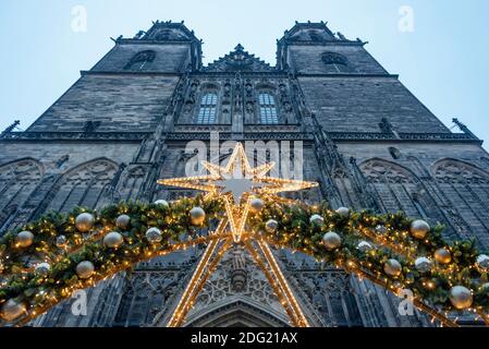 Magdeburg, Germany. 01st Dec, 2020. A poinsettia shines in front of the cathedral. It belongs to the world of lights, which is to remain erected until 2 February 2021. Credit: Stephan Schulz/dpa-Zentralbild/ZB/dpa/Alamy Live News Stock Photo