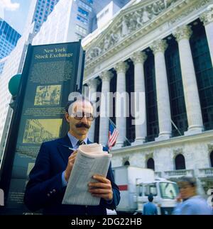 New York 1985, man checking share prices in The Wall Street Journal, NYSE Stock Exchange building facade, Broad street, Manhattan, New York City, NY, NYC, USA, Stock Photo