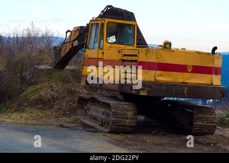 An Old Dirty Yellow Red  excavator Stock Photo