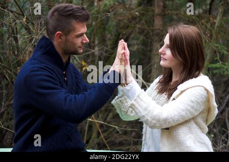 Young couple holding hands in the forest in front of trees Stock Photo