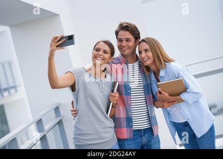 Group of students using smartphone in the campus Stock Photo