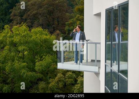 Businessman standing on balcony against nature Stock Photo