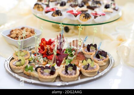 The buffet at the reception. Assortment of canapes on a table. Banquet service. Catering food, snacks with different types of cheese, ham, salami, pro Stock Photo