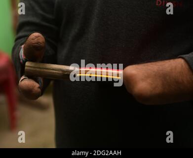 Kajol Dey, a 49 year old disabled table tennis player and coach is seen getting ready to coacha young girl at his coaching camp on International Day of Persons with Disabilities (IDPD). Agartala, Tripura, India. Stock Photo