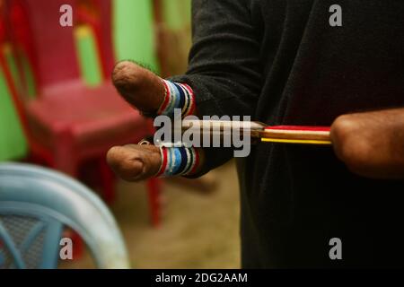 Kajol Dey, a 49 year old disabled table tennis player and coach is seen getting ready to coach a young girl at his coaching camp on International Day of Persons with Disabilities (IDPD). Agartala, Tripura, India. Stock Photo