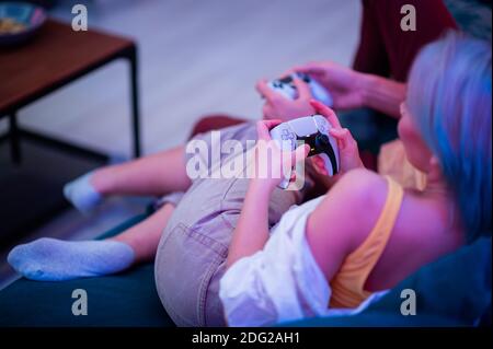 Different generations of PlayStation console controllers: PS5 DualSense controller and PS4 DualShock controller in a hands of gamers. Moscow - Stock Photo