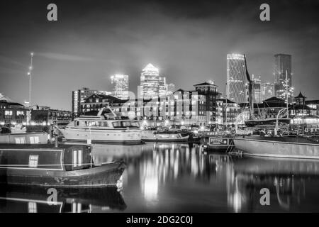 London, Tower Hamlets, Limehouse, Limehouse Basin waterside & marina, houseboats, illuminated skyline of the docklands financial district, night shot