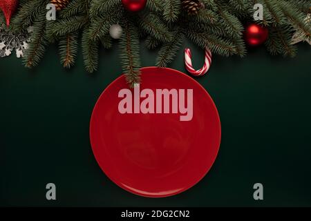 An empty red plate stands on the Christmas table. Stock Photo