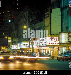 New York 1985, 42nd street at night, moving cars traffic, motion effect, lit movie theatres marquees, midtown Manhattan, New York City, NY, NYC, USA, Stock Photo