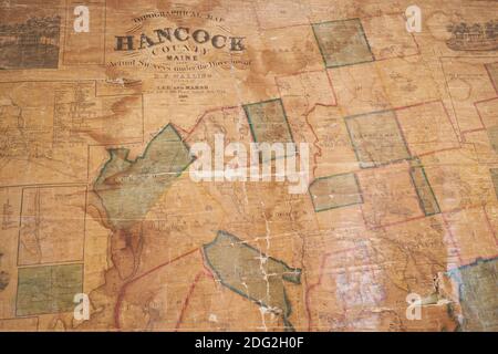 An old wall map of local Hancock County hangs at the restored Surry Village School. In Surry, Maine. Stock Photo