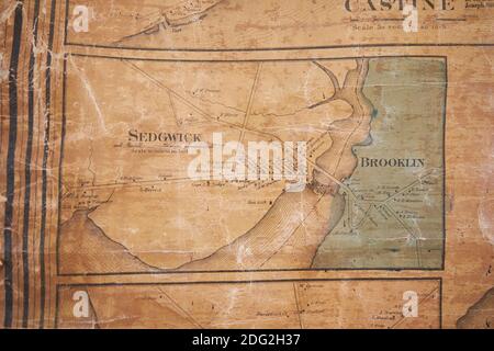 An old wall map with detail of Sedgwick and Brooklin of local Hancock County hangs at the restored Surry Village School. In Surry, Maine. Stock Photo