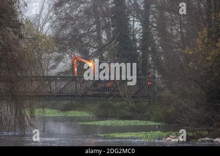 Denham, UK. 7th December, 2020. An excavator is driven across a bridge in Denham Country Park during works for the building of a bridge in connection with the HS2 high-speed rail link. Anti-HS2 activists continue to resist the controversial £106bn rail project from a series of protest camps based along its initial route between London and Birmingham. Credit: Mark Kerrison/Alamy Live News Stock Photo