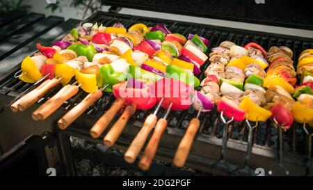 Chef cooking barbecue with skewers on grilled meat. Very delicious brochette on a barbecue in backyard. Food cooked with grilling BBQ in the garden of Stock Photo