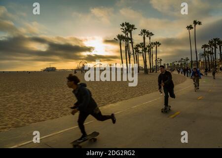 Skateboarders and Santa Monica Pier at sunset, Santa Monica, Los Angeles, California, United States of America, North America Stock Photo