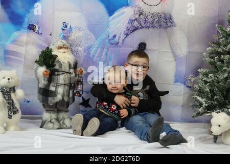 A traditional happy family Christmas photoshoot with a Christmas backdrop Stock Photo