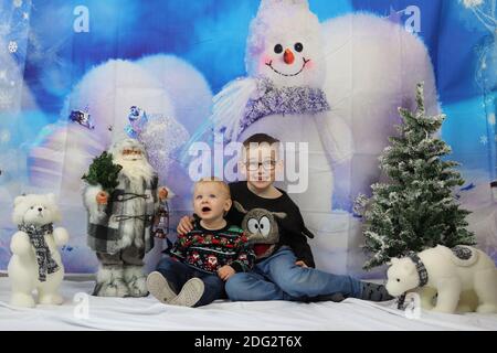 A traditional happy family Christmas photoshoot with a Christmas backdrop Stock Photo