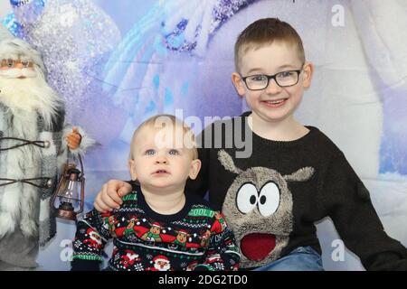 A traditional happy family Christmas photoshoot with a Christmas backdrop Stock Photo