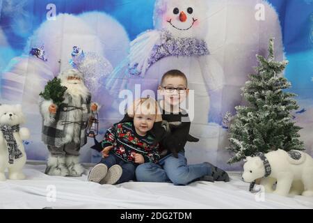 A traditional happy family Christmas photoshoot with a Christmas backdrop Stock Photo