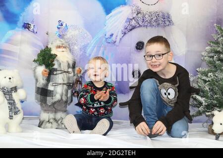 A traditional happy family Christmas photoshoot with a Christmas backdrop Stock Photo