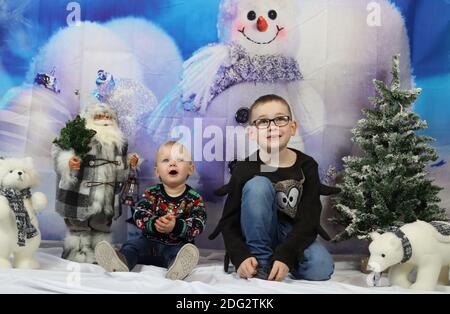 A traditional happy family Christmas photoshoot with a Christmas backdrop Stock Photo