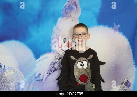 A traditional happy family Christmas photoshoot with a Christmas backdrop Stock Photo