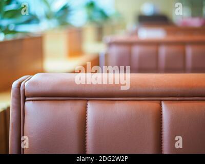 Brown leather seats in a row with flowers at the background Stock Photo