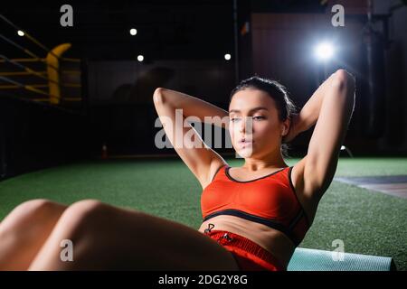 athletic sportswoman doing press ups exercise in gym on blurred foreground Stock Photo